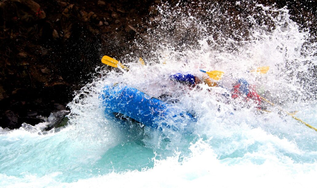 River Rafting a raft blasting through a wave